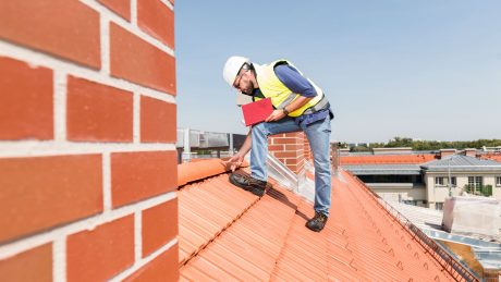 Man checks tiles on roof