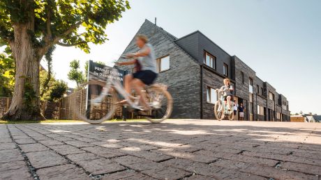 Woman riding her bike on clay pavements, blue sky