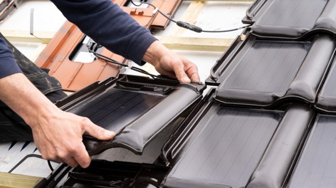 schwarze Solardachziegel wird vom Dachdecker installiert
