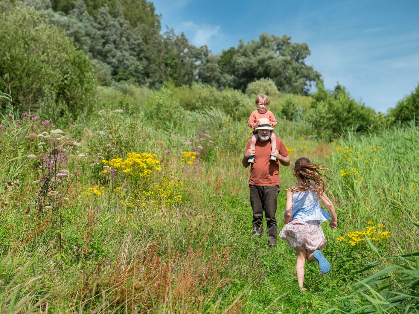 Blumenwiese, ein Mann mit zwei Kinder