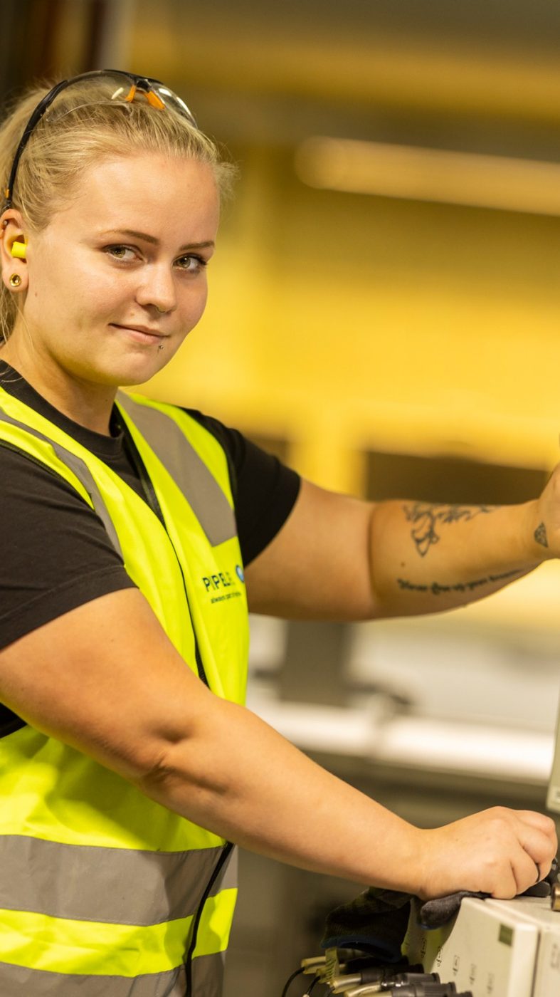 Eine Frau in Schutzkleidung an einer Produktionsmaschine