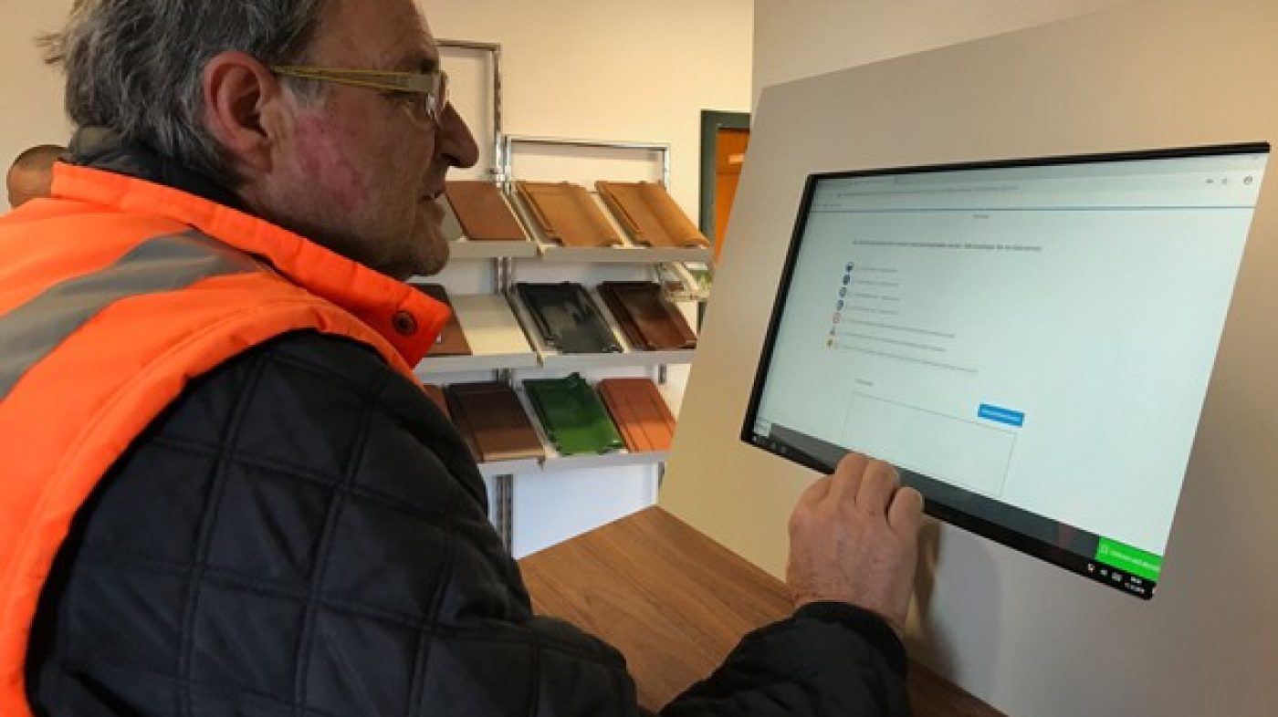 Mann mit Sicherheitsweste schaut auf Bildschirm