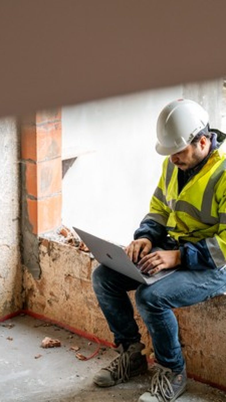 Baustelle, Mann arbeitet mit Laptop