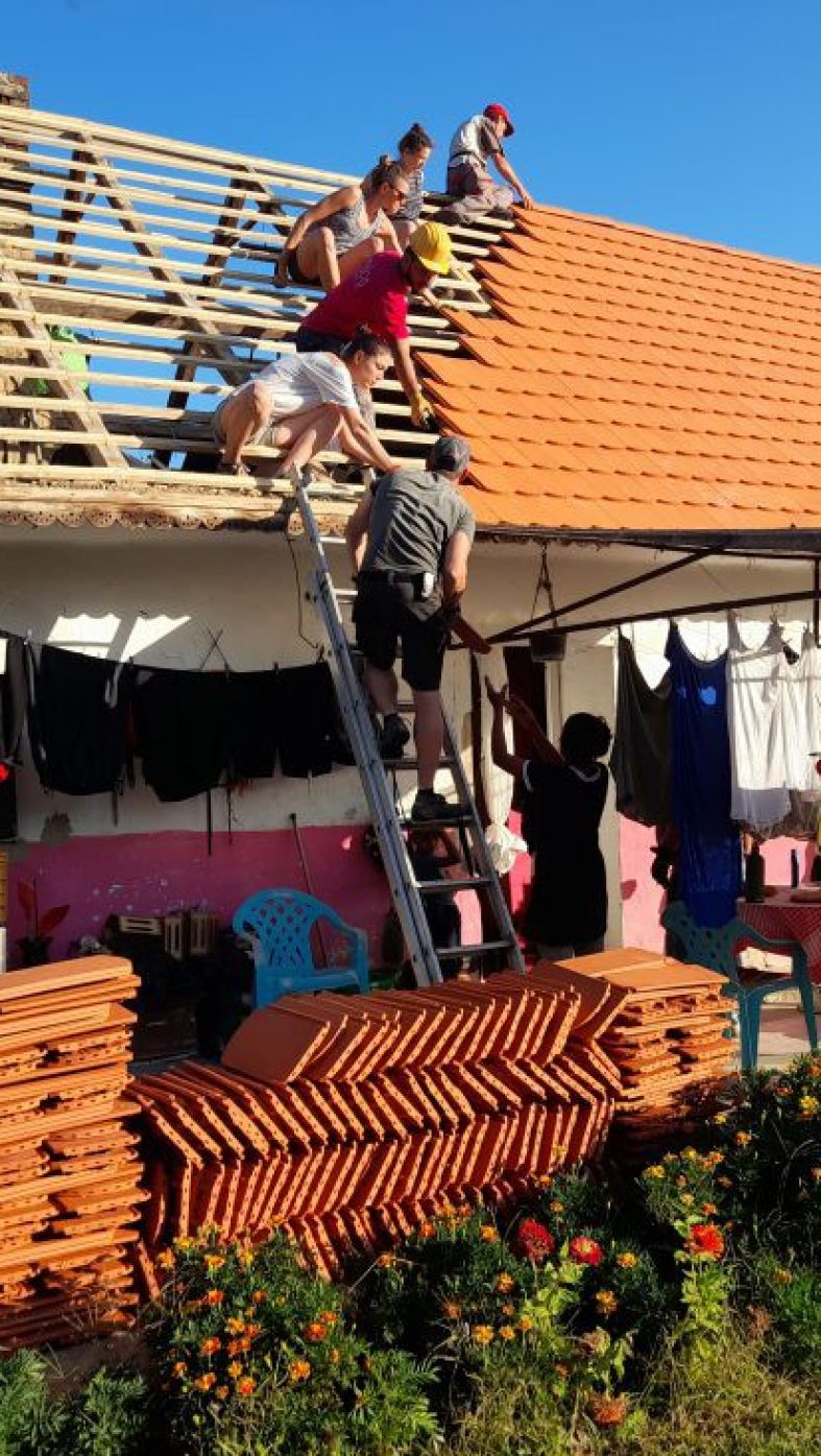 Viele Menschen bauen zusammen einen Dach