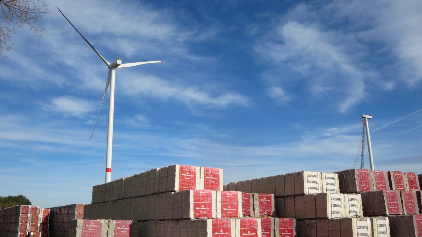 Ziegellagerplatz mit Windrädern im Hintergrund, blauer Himmel
