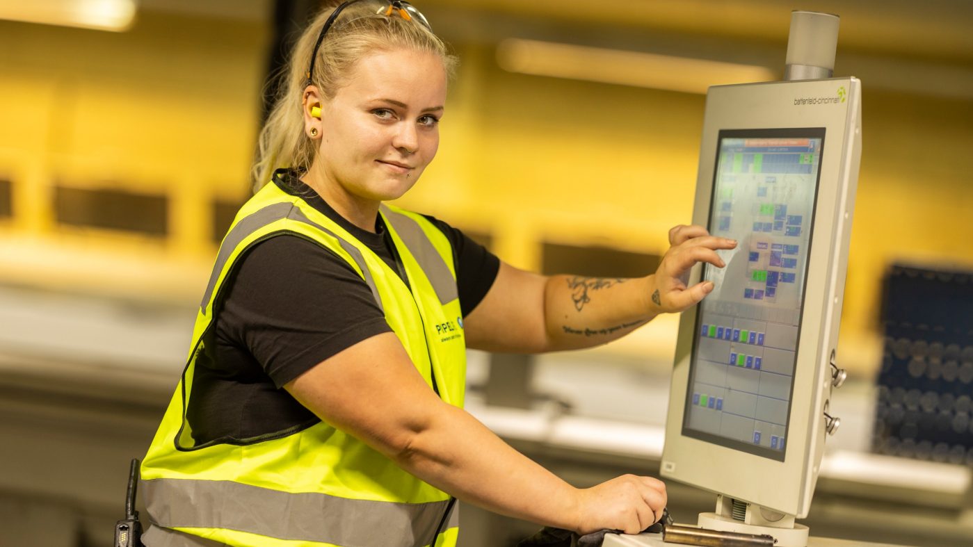 Eine Angestellte steuert Produktionsanlagen per Monitor