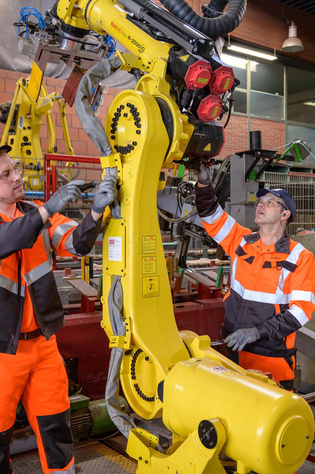 Zwei Männer arbeiten an einer Maschine in einer Fabrik