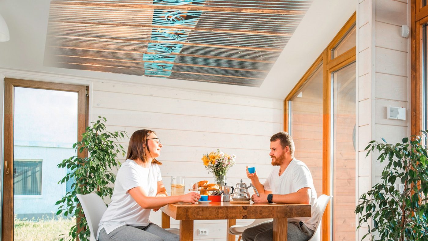 Ein Ehepaar entspannt sich in seinem Haus mit einem in der Decke installierten Kühlsystem