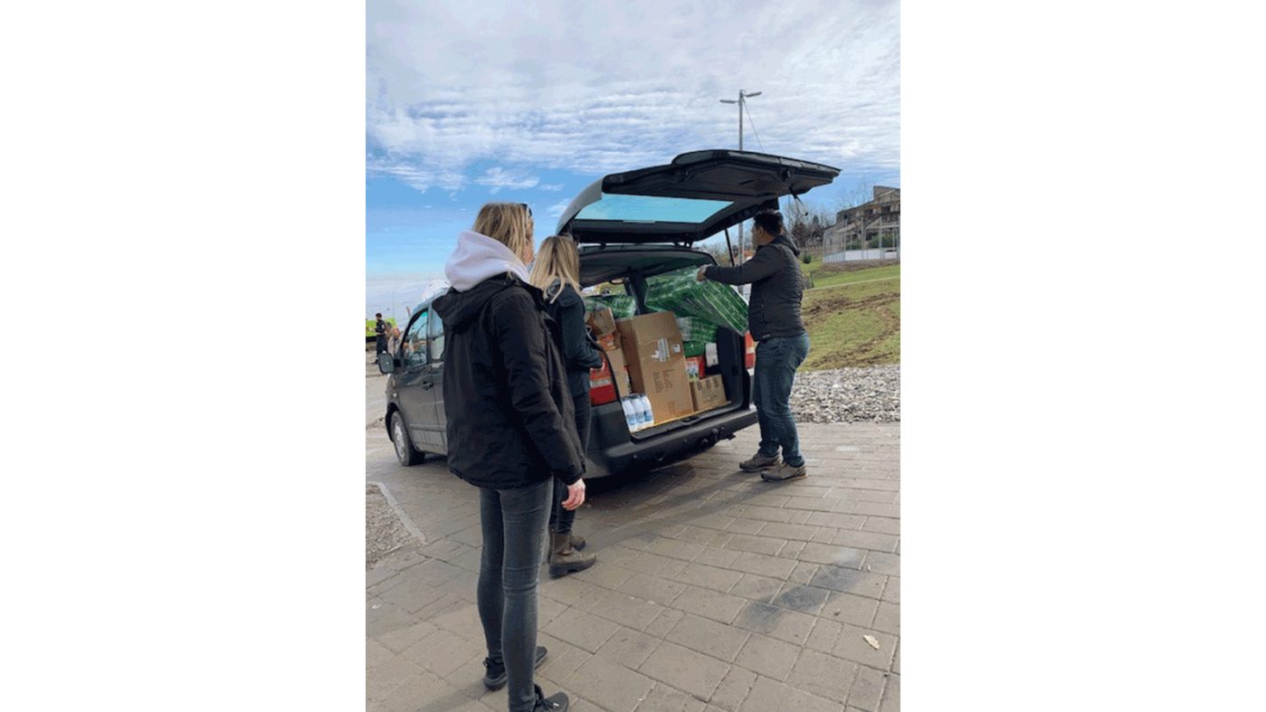 People in front of a trunk filled with relief supplies