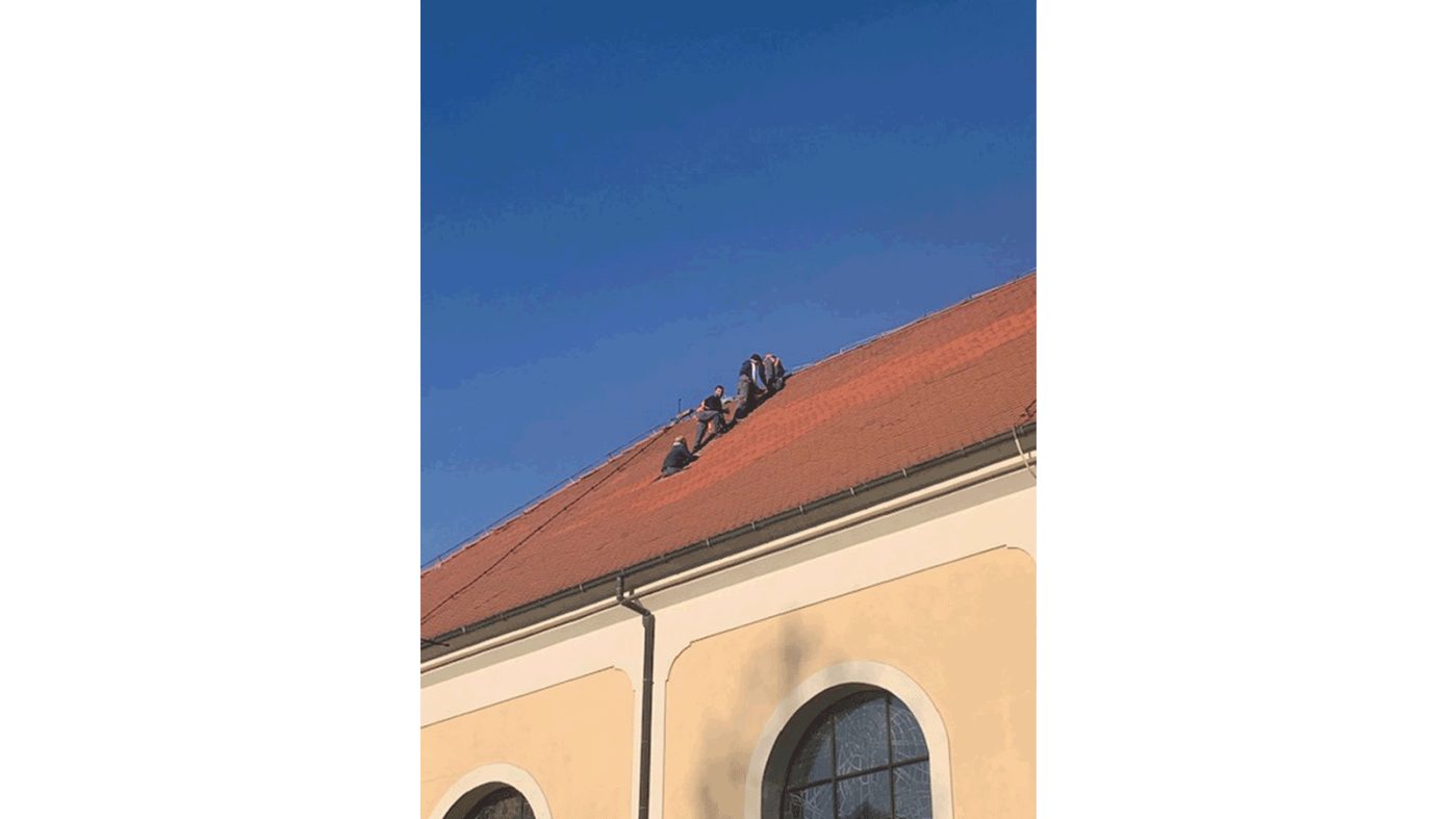 People repairing a church roof