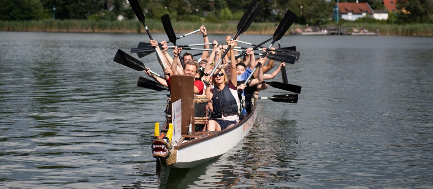Dragon boat, people holding padel in the air