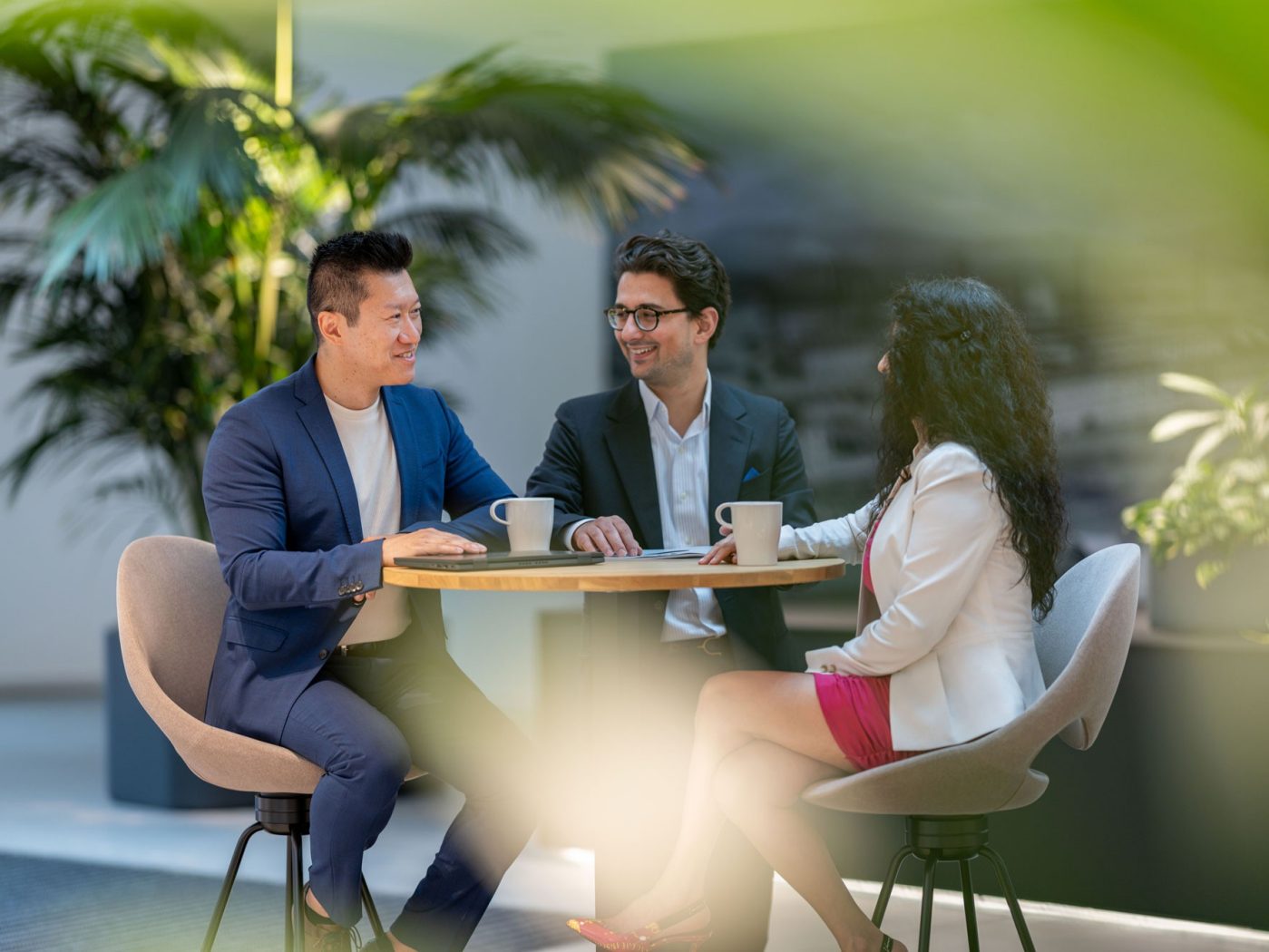 three people sitting at a table talking