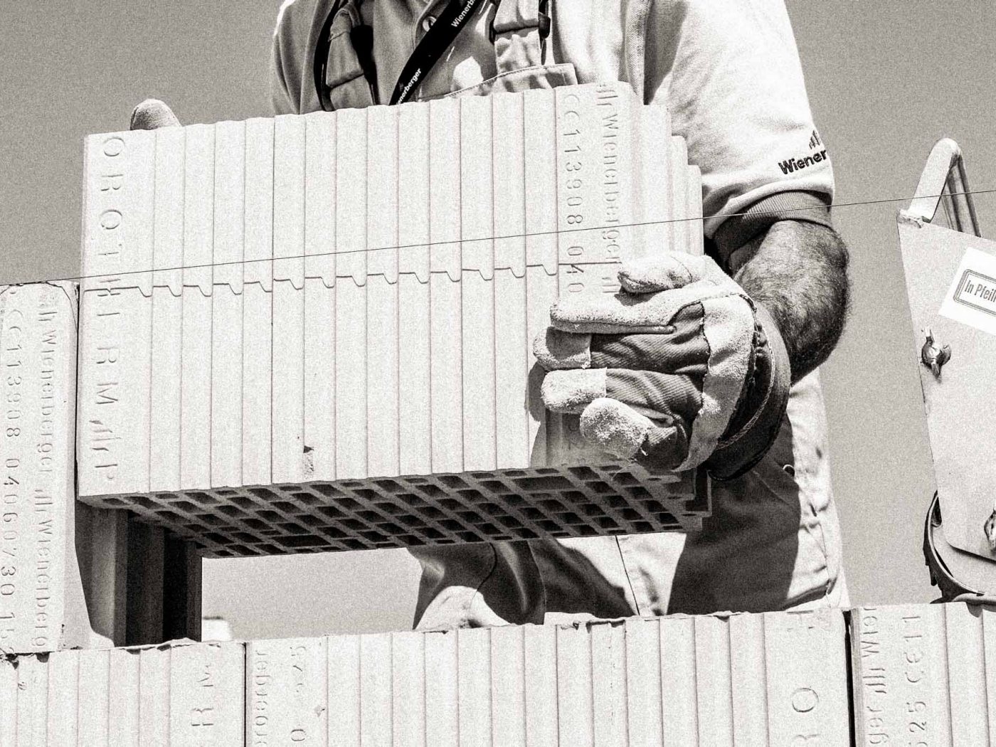 black an white fotograph, mason laying bricks
