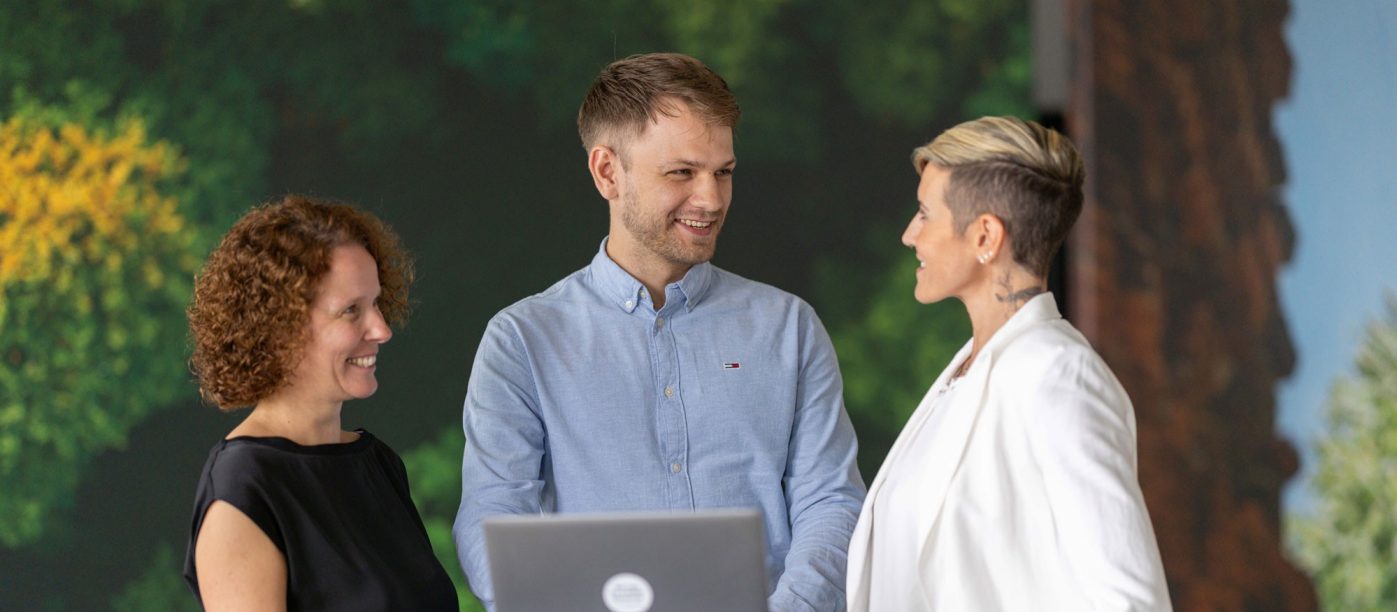 Three people standing together laughing