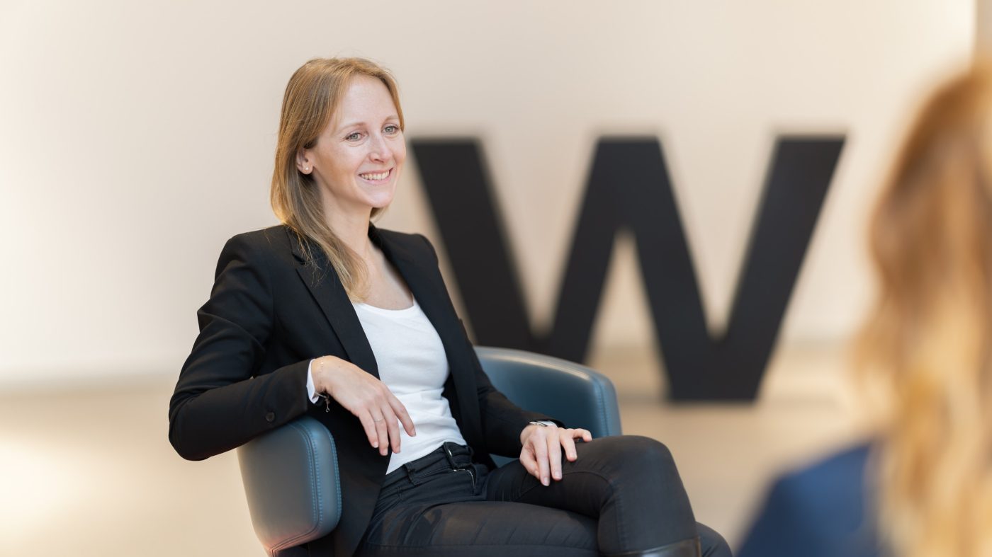 Two women in a meeting, smiling, laptop