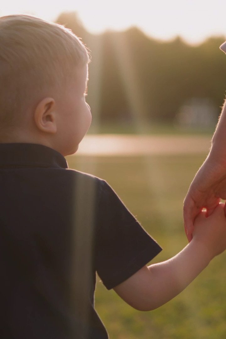 Child hold hand of a women, walking