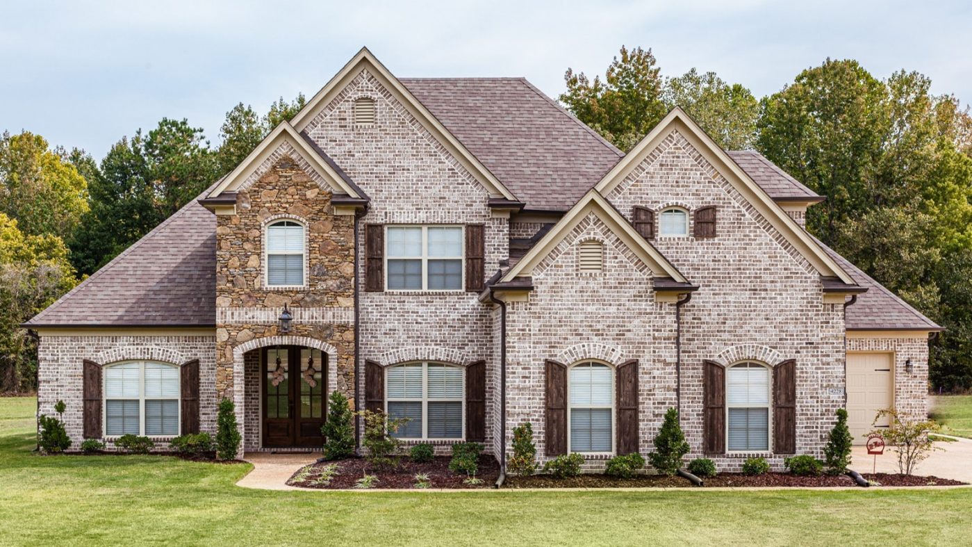 Brick home inmidst a green meadow