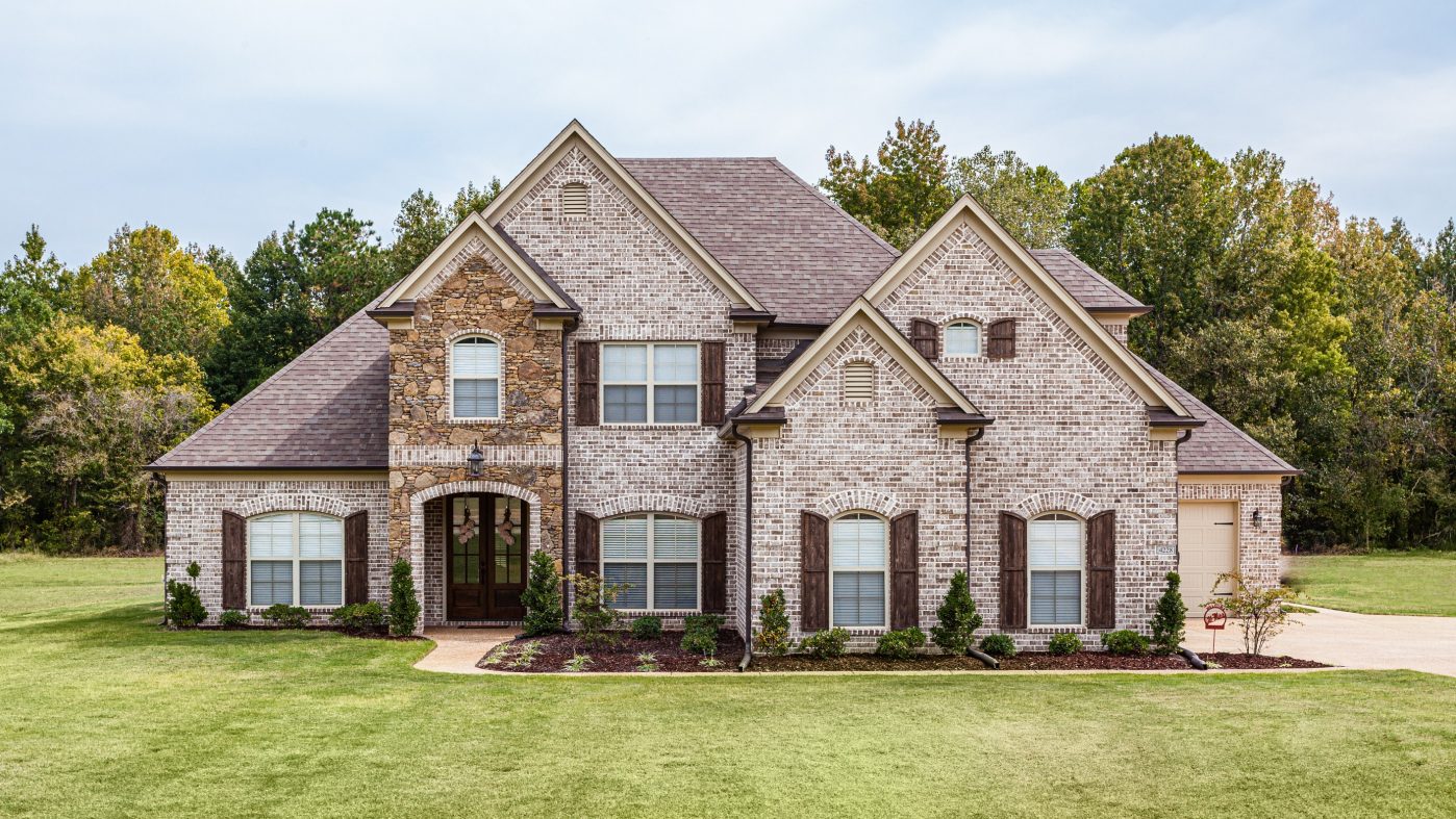 Brick home inmidst a green meadow