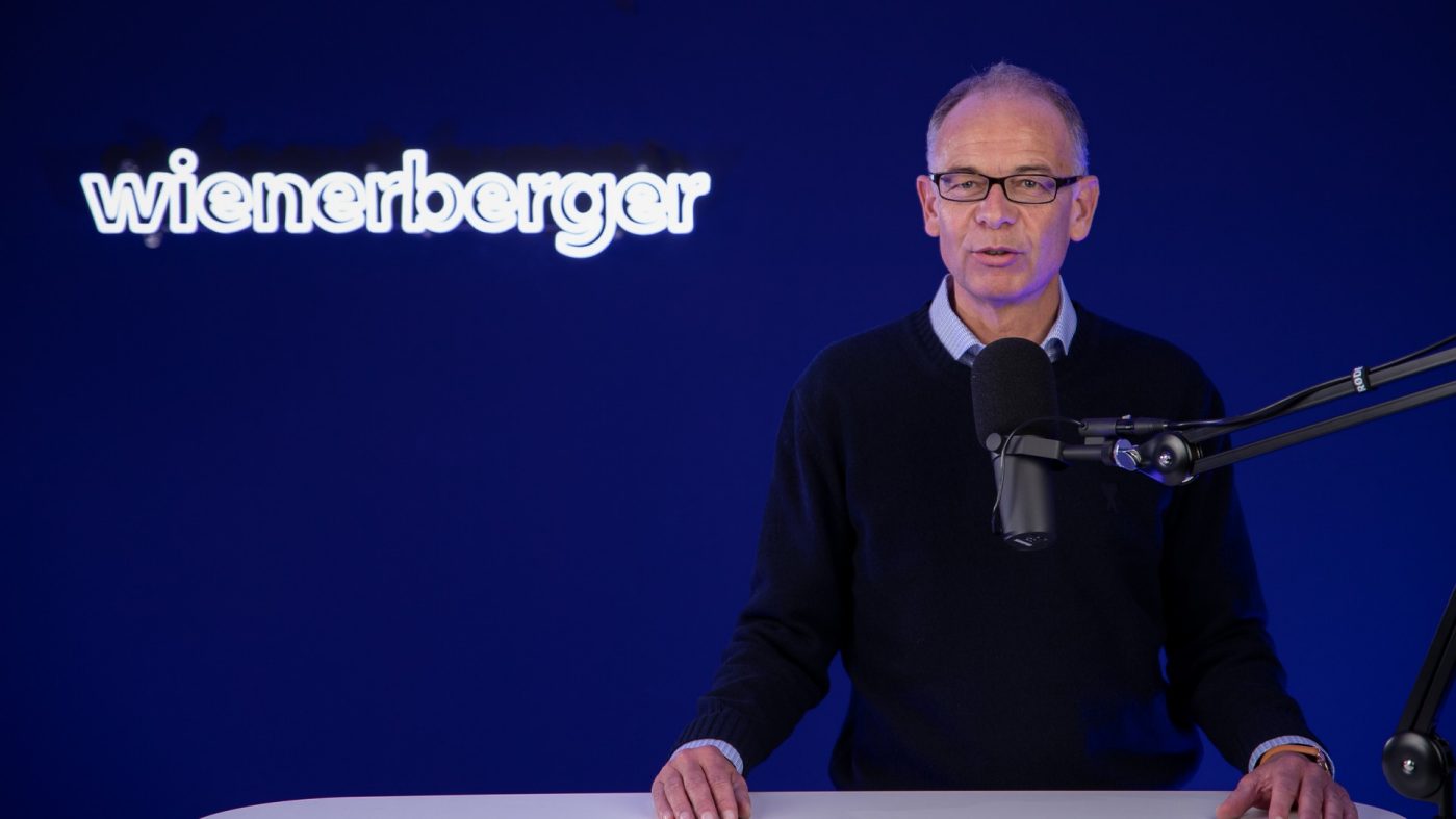 Wienerberger AG CEO Heimo Scheuch infront of blue background with Wienerberger logo