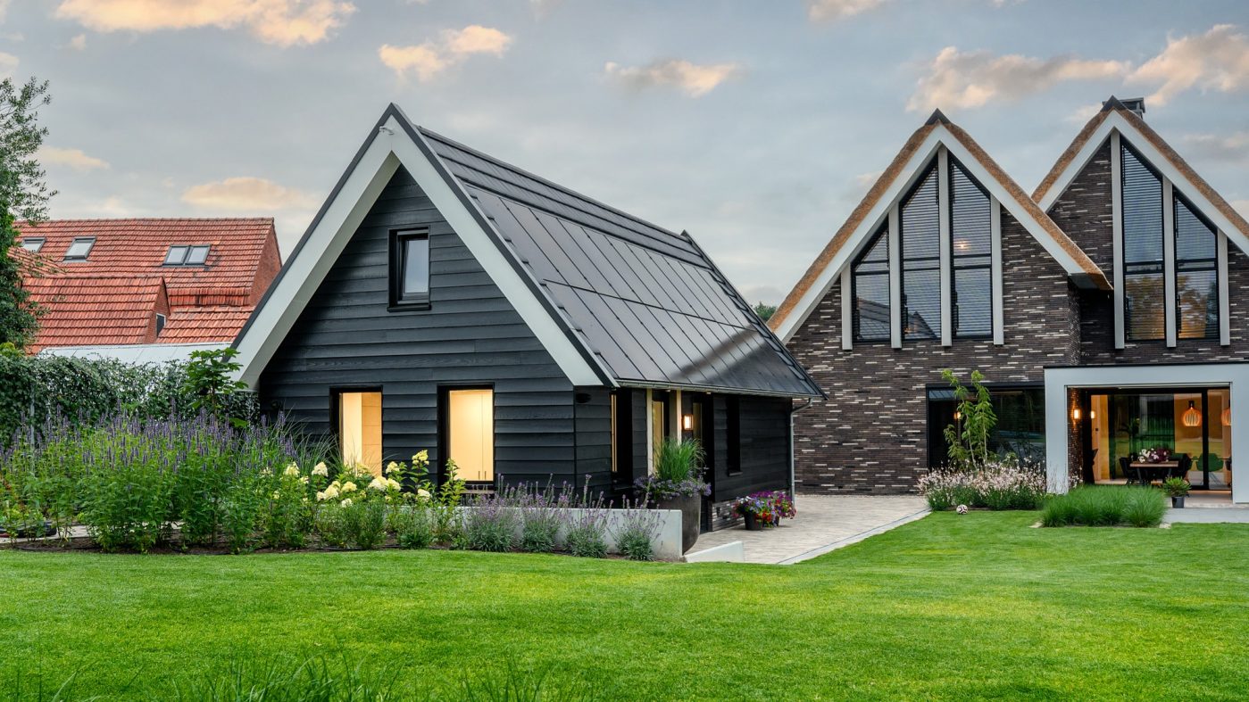 Garden shed with photovoltaik on the roof, brick house in the back