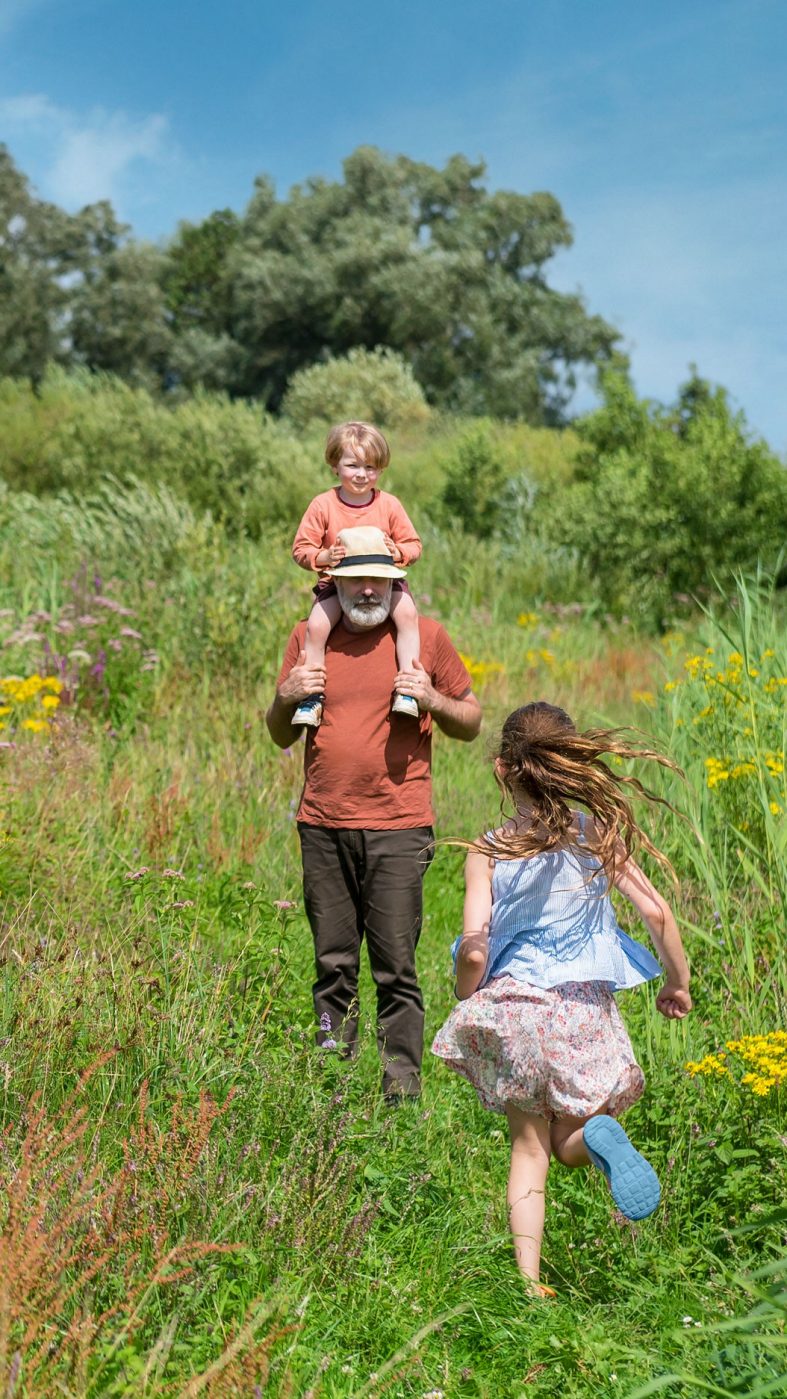 A man and two children on a green meadow
