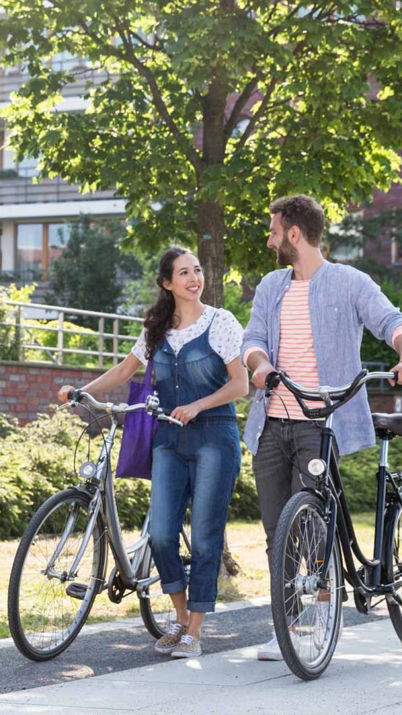 woman and man with bicycles on clay pavement