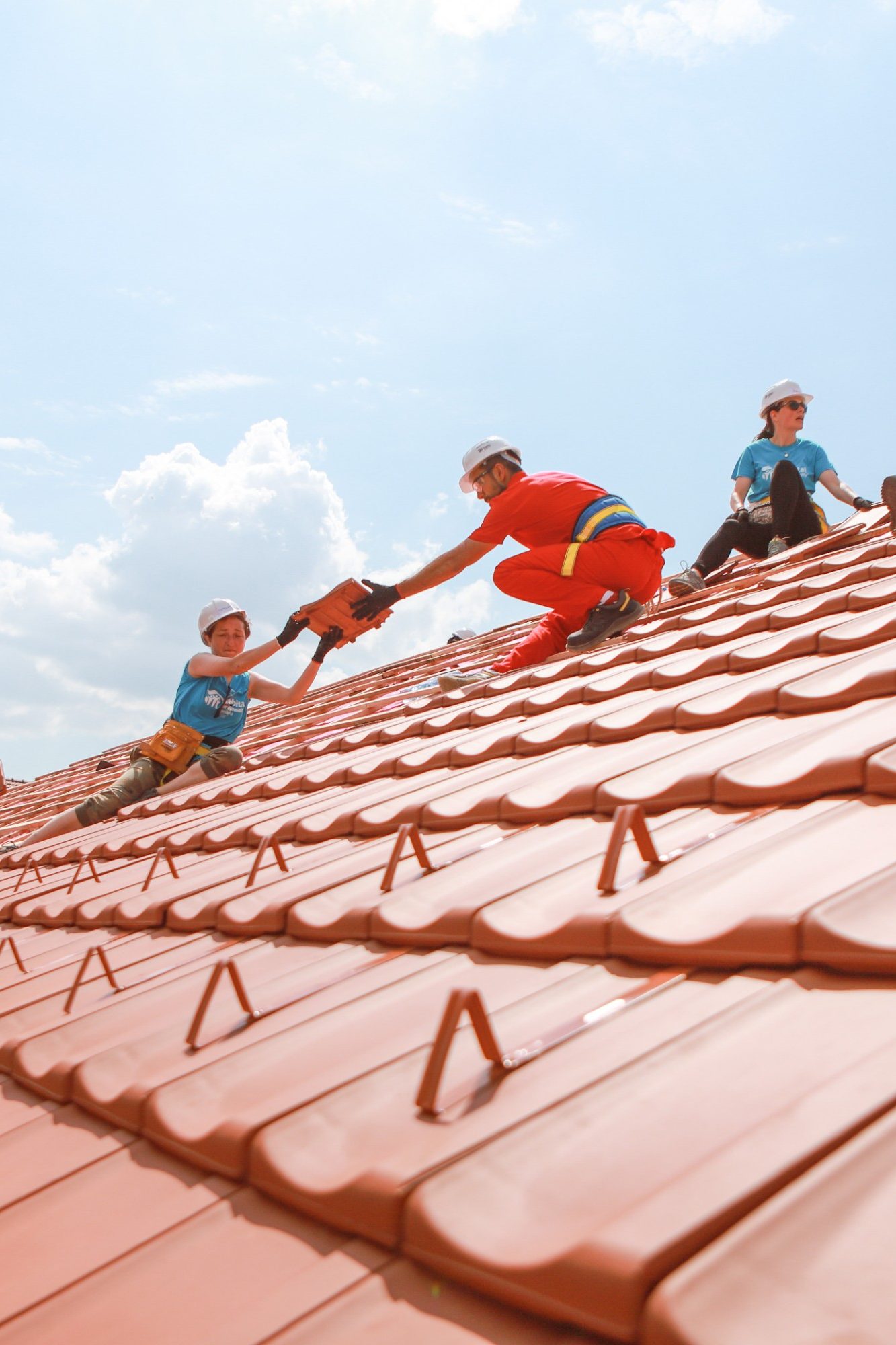people cover a roof together