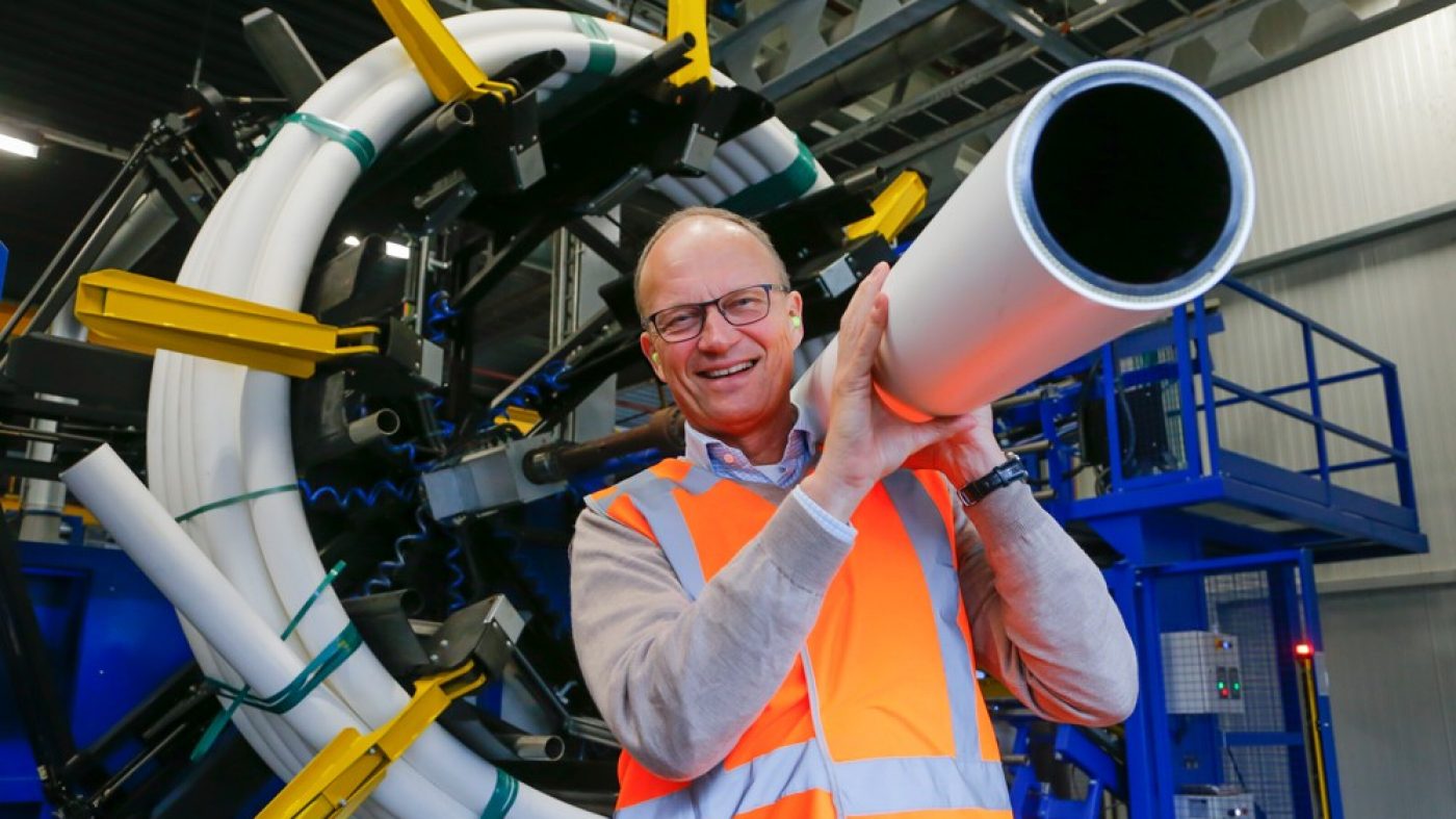 Mark van Loon holding a Pipelife pipe on his shoulder