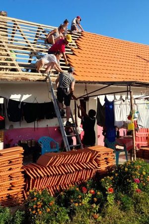 Many people are building a roof together