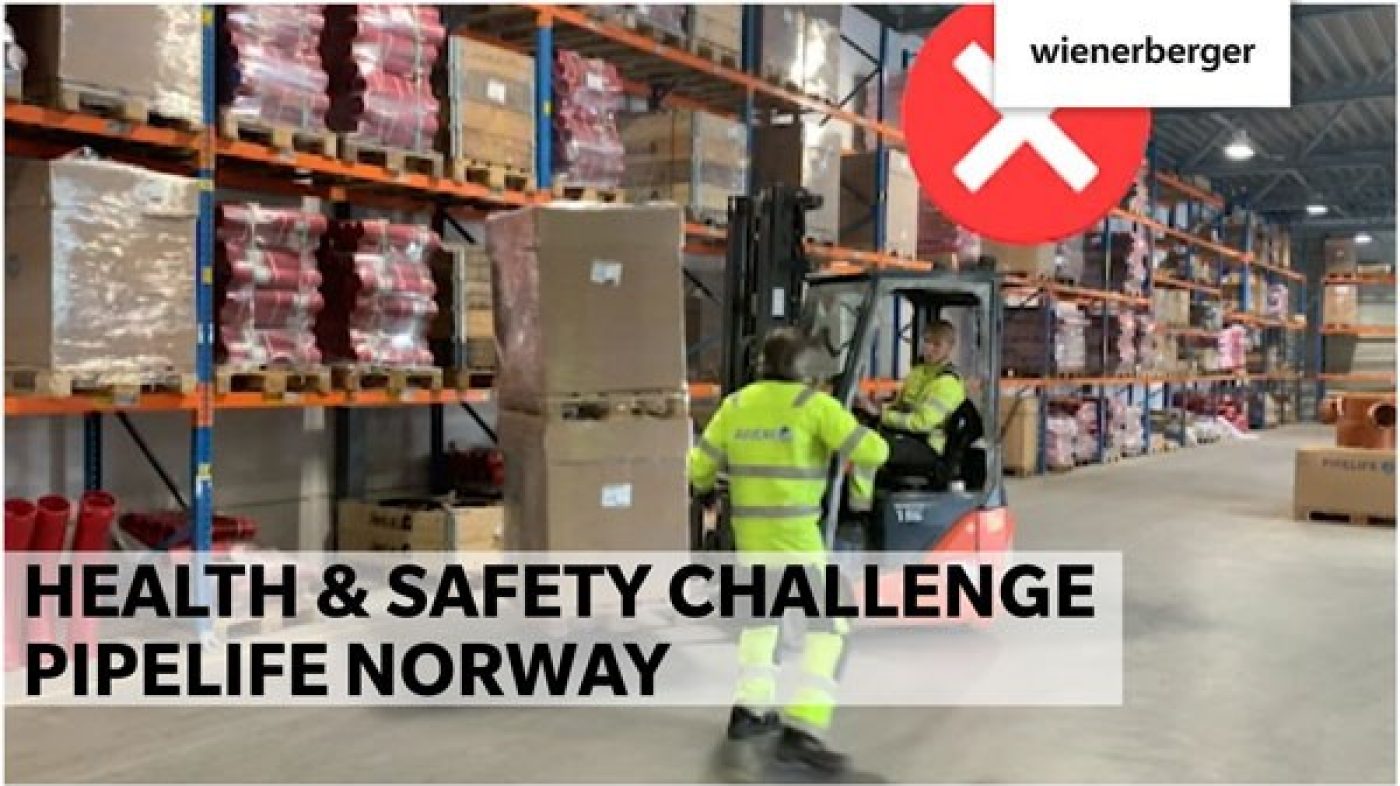 One man in protective clothing and another in a forklift are in the warehouse