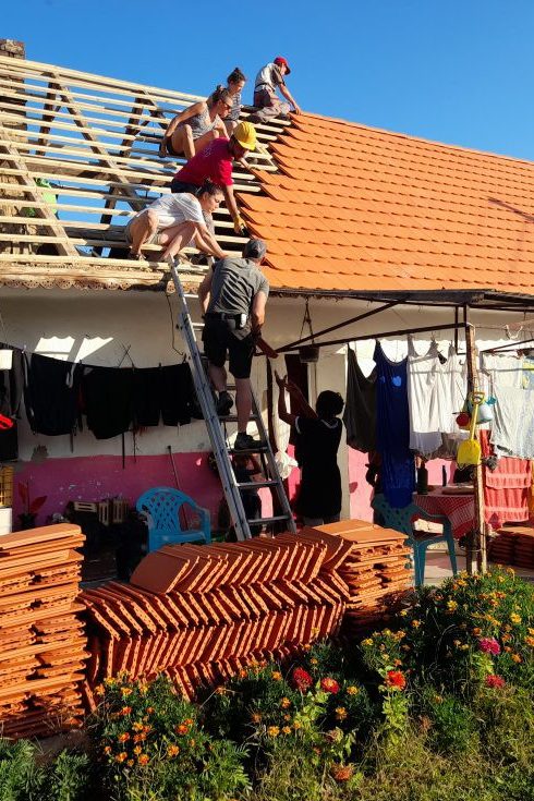 Many people are building a roof together