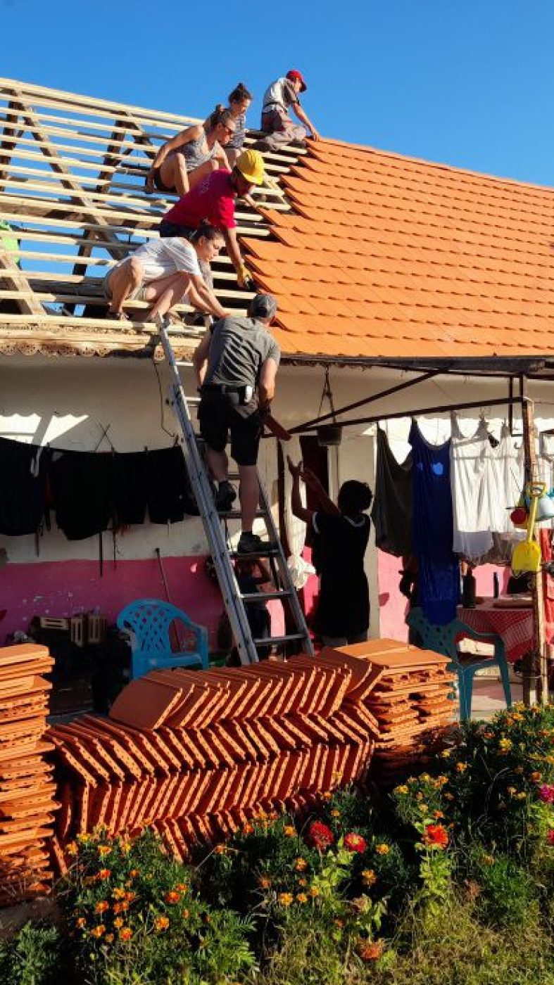 Many people are building a roof together