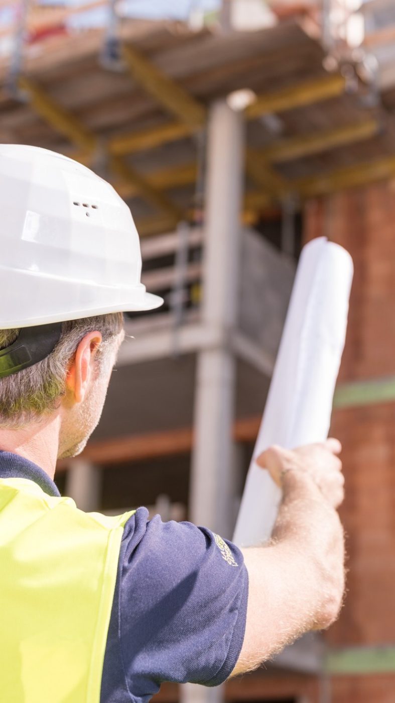 Brick building under construction, two man pointing at building