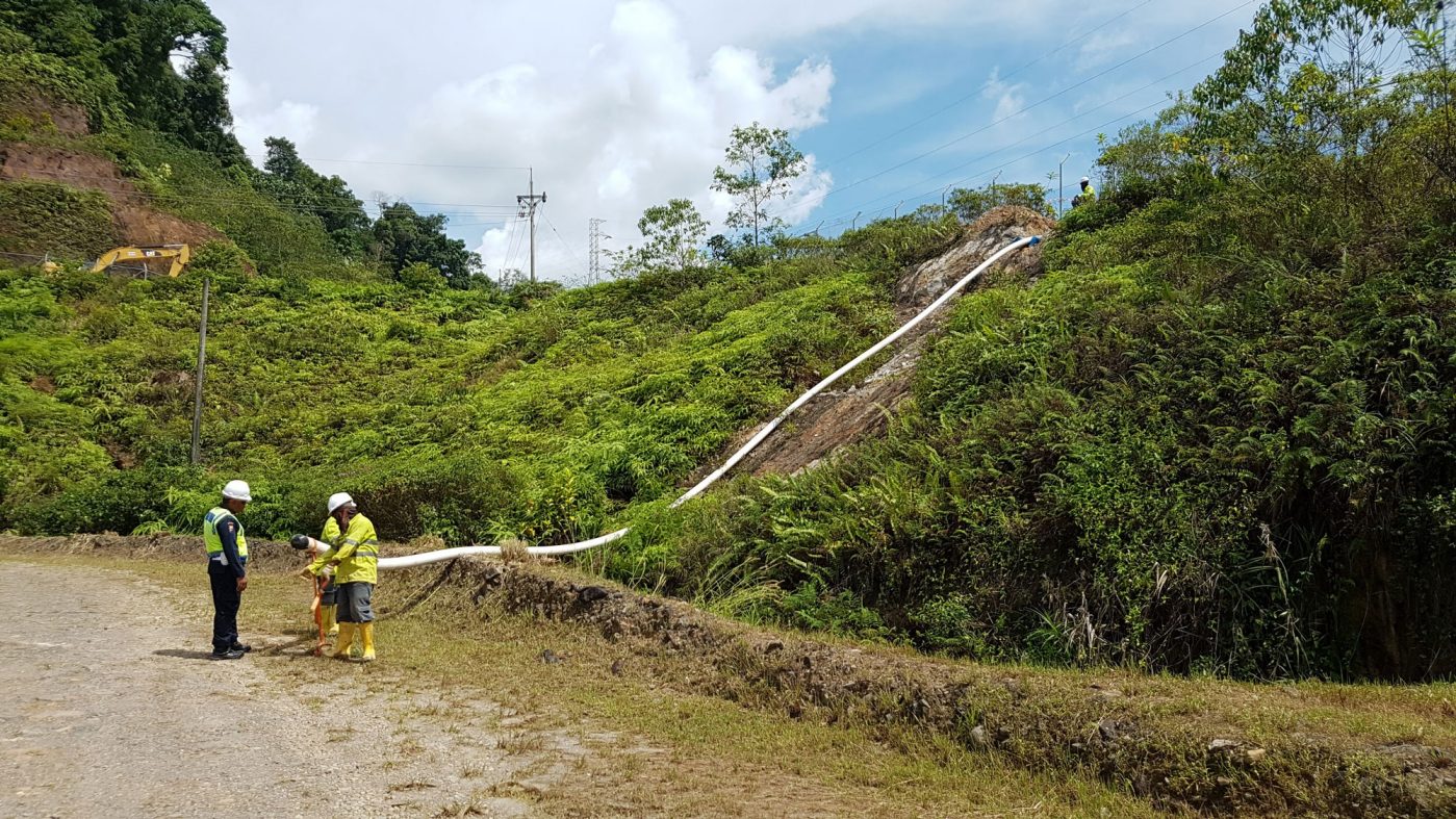 SoluForce pipes in rough terrain, three people with safety clothing