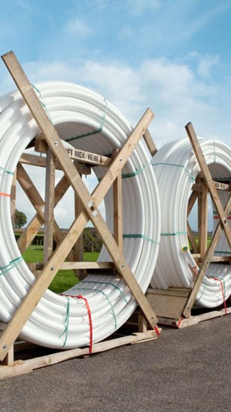 white tubes coiled; green meadow, blue sky
