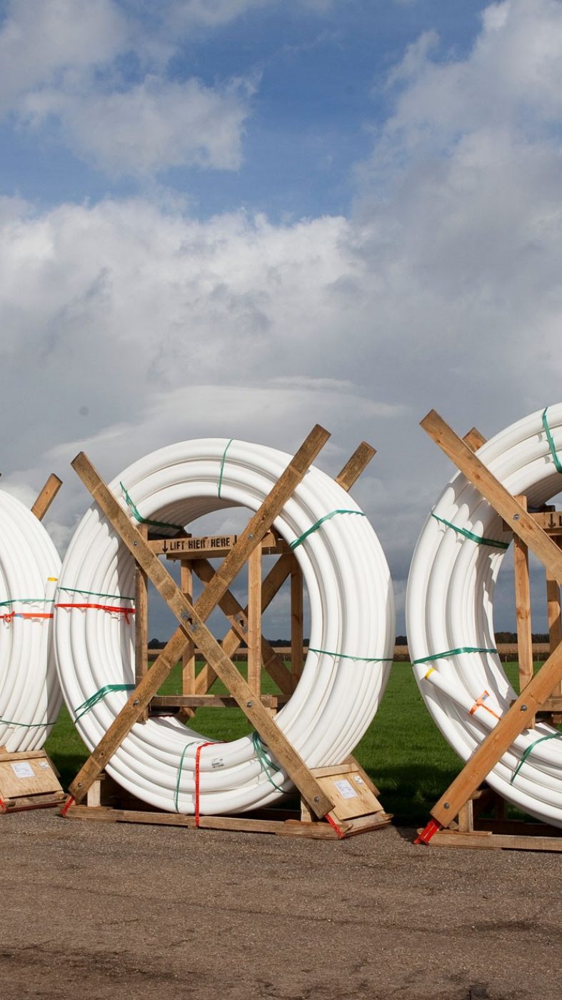 white tubes coiled; street, green meadow, blue sky