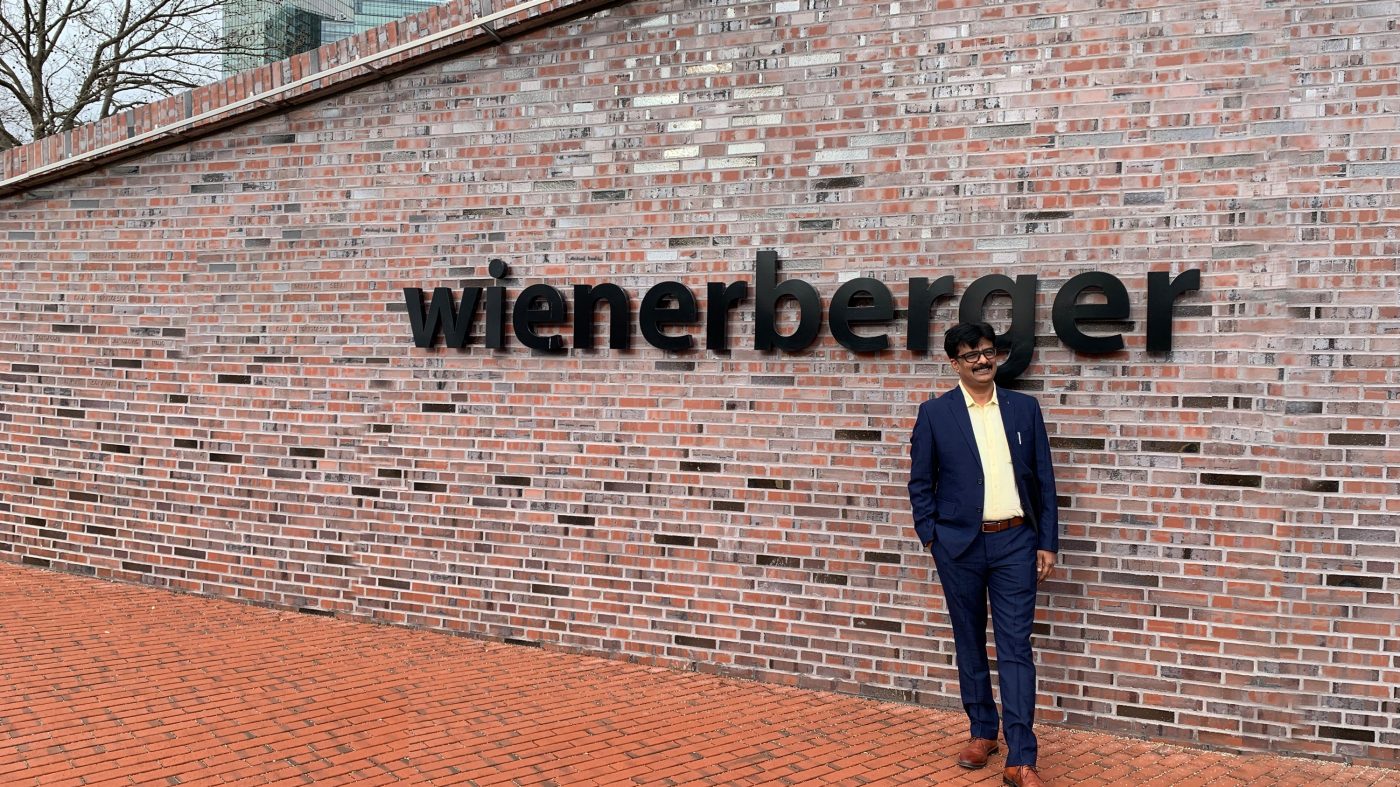 Man in front of Wienerberger logo on brick wall