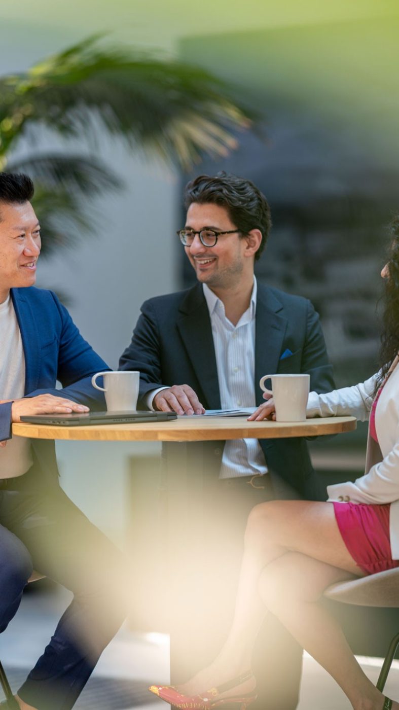 three people sitting at a table talking