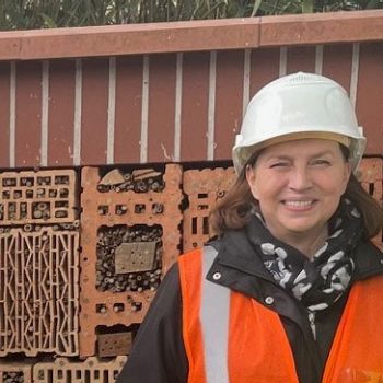 A woman infront of a insect hotel