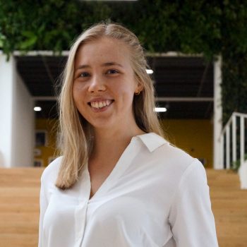 Blond woman smiling, stairs in the background