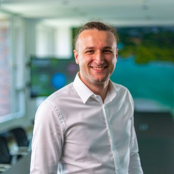 Man smiling into camera, meeting room