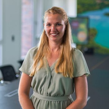 woman smiling into camera, meeting room setting