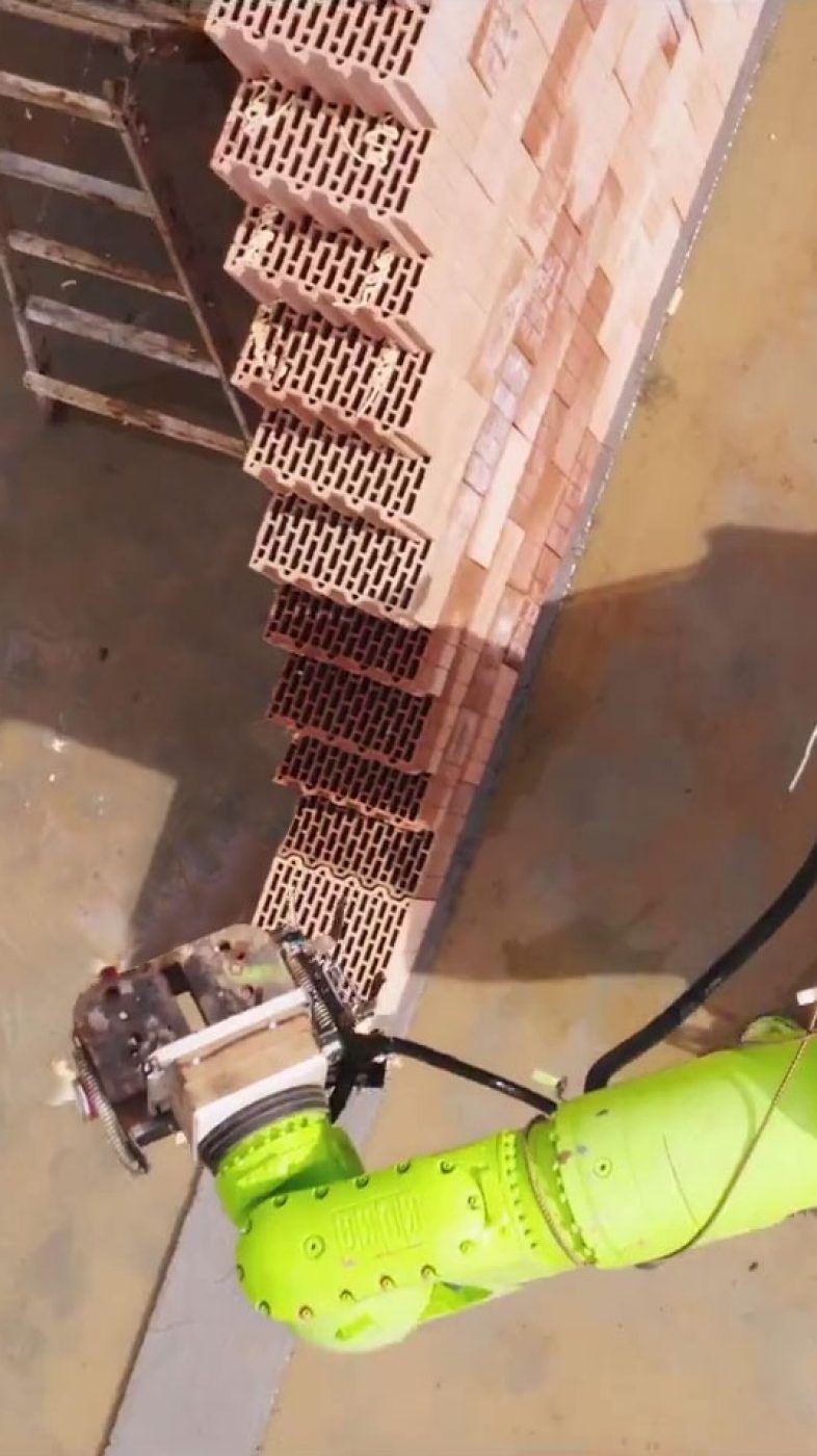 Construction site, light green robot setting bricks